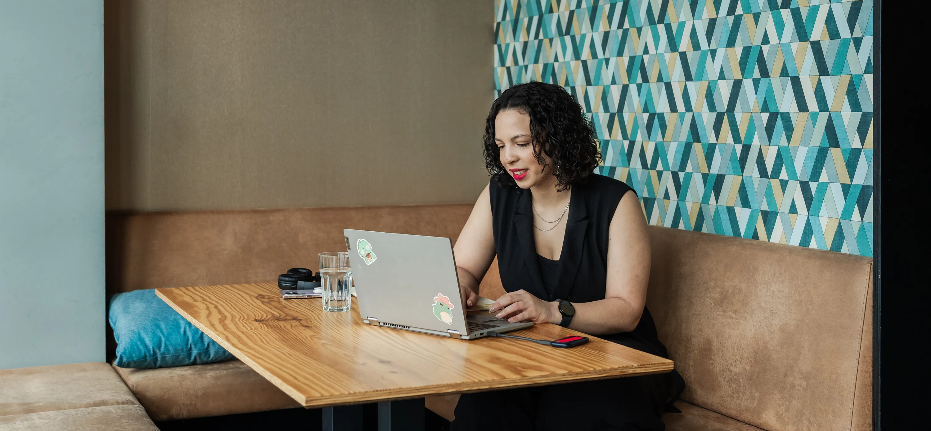 Businessportrait einer jungen Frau, die in einem Café mit ihrem Laptop arbeitet